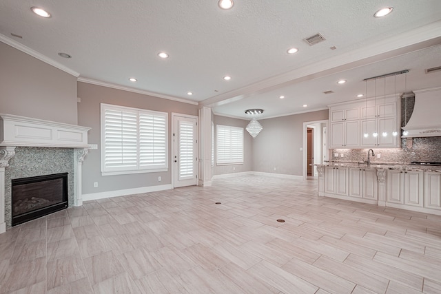 unfurnished living room with crown molding, baseboards, and a premium fireplace