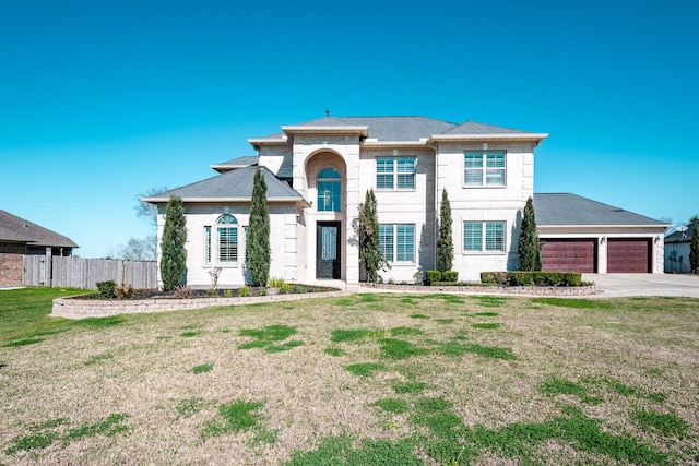 view of front facade with fence, roof with shingles, a front lawn, concrete driveway, and a garage