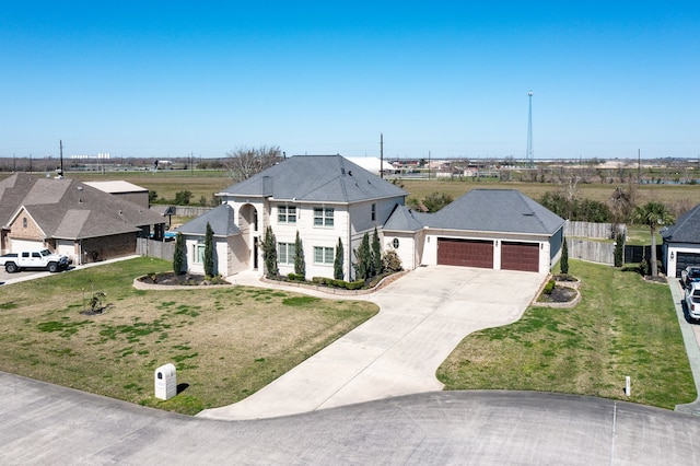 view of front of property featuring a front lawn, fence, a garage, and driveway