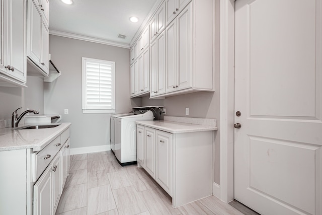 laundry room with visible vents, ornamental molding, washer and dryer, cabinet space, and a sink