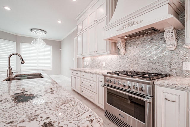 kitchen with tasteful backsplash, custom range hood, ornamental molding, stainless steel stove, and a sink