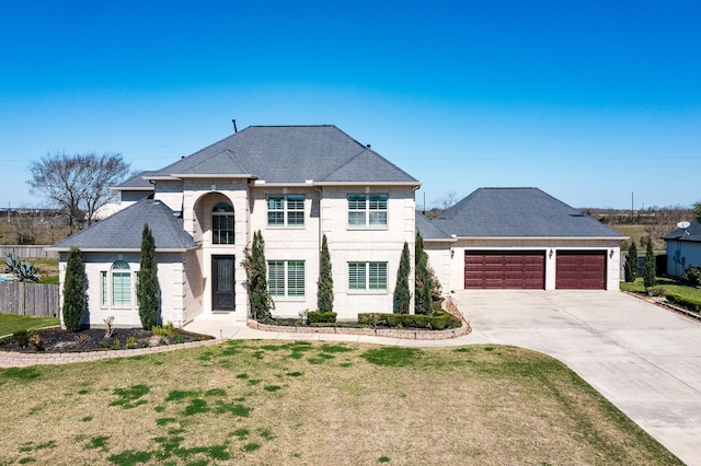 french country style house featuring a front yard, fence, roof with shingles, concrete driveway, and a garage