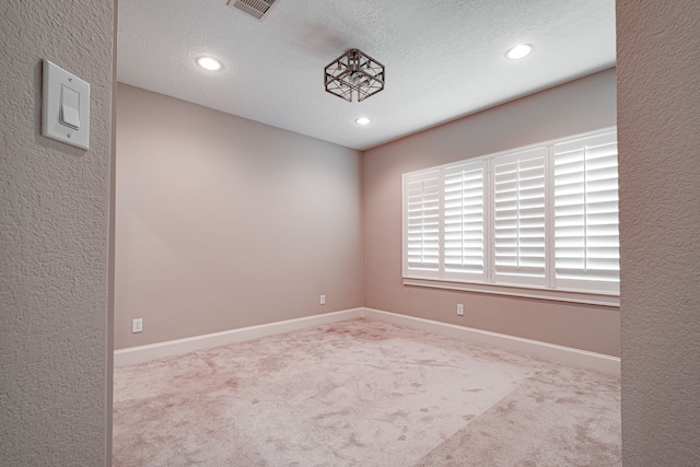 unfurnished room featuring visible vents, baseboards, carpet floors, recessed lighting, and a textured ceiling