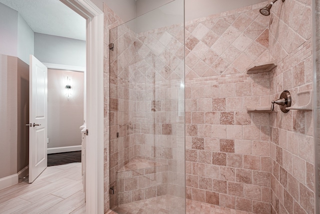 full bathroom with baseboards and a shower stall