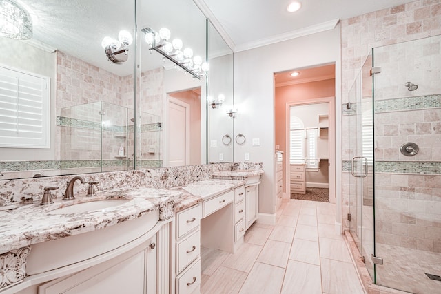 full bathroom featuring a sink, a stall shower, ornamental molding, and double vanity