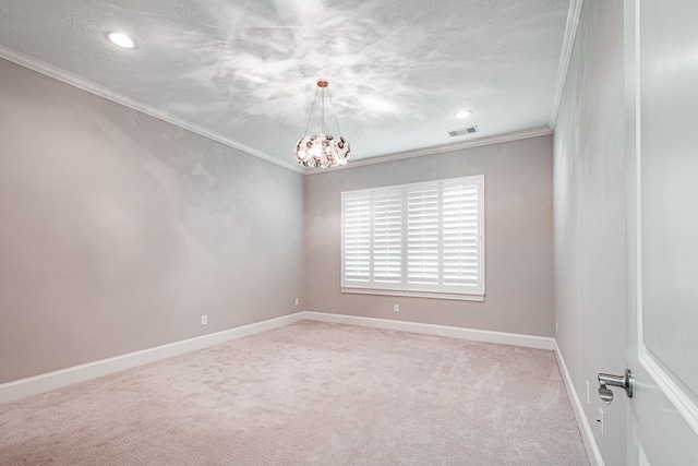 spare room featuring visible vents, ornamental molding, a textured ceiling, baseboards, and light colored carpet