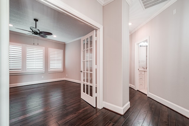 unfurnished room featuring visible vents, baseboards, dark wood-type flooring, and crown molding