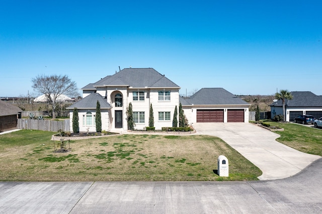 view of front facade with an attached garage, concrete driveway, a front lawn, and fence