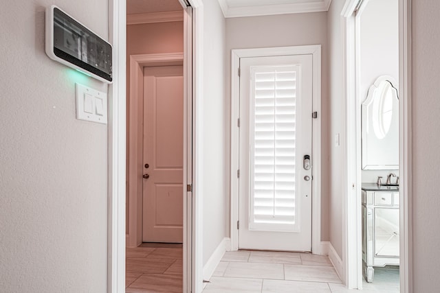 interior space featuring a sink, baseboards, and ornamental molding