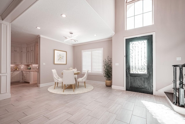 foyer entrance featuring light wood-style floors, recessed lighting, crown molding, and baseboards