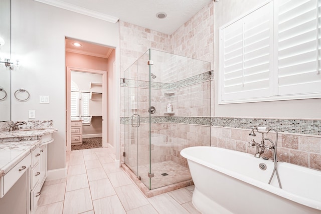 bathroom with vanity, a freestanding tub, a stall shower, ornamental molding, and a spacious closet