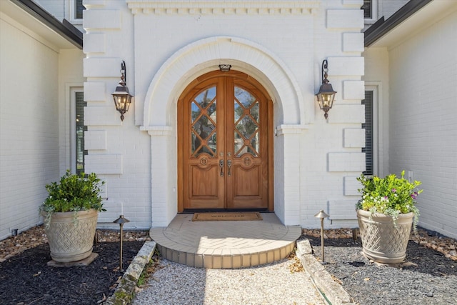 view of exterior entry featuring brick siding