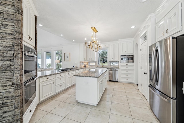 kitchen featuring light tile patterned floors, light stone countertops, appliances with stainless steel finishes, and white cabinets