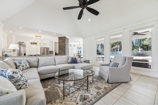 living room featuring light tile patterned floors, ceiling fan with notable chandelier, arched walkways, and high vaulted ceiling