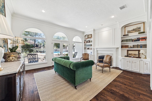 living area featuring visible vents, a textured ceiling, dark wood finished floors, french doors, and a fireplace