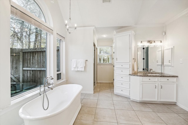 bathroom featuring tile patterned flooring, visible vents, a chandelier, a freestanding bath, and vanity