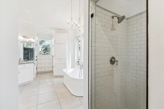 bathroom with a stall shower, tile patterned flooring, a freestanding bath, a chandelier, and vanity