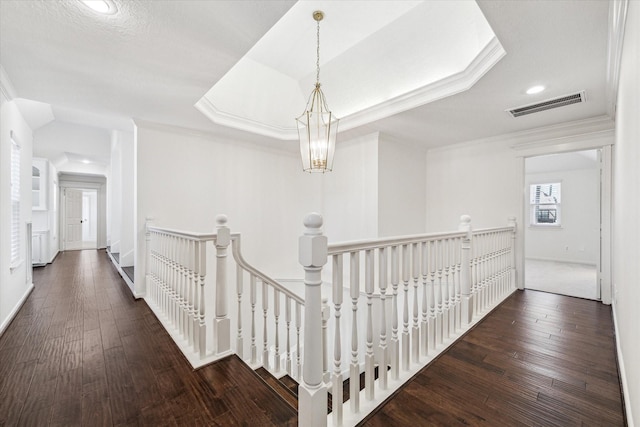 corridor featuring visible vents, an upstairs landing, hardwood / wood-style floors, and crown molding