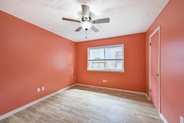 unfurnished bedroom featuring a ceiling fan, light wood-style floors, baseboards, and a textured ceiling