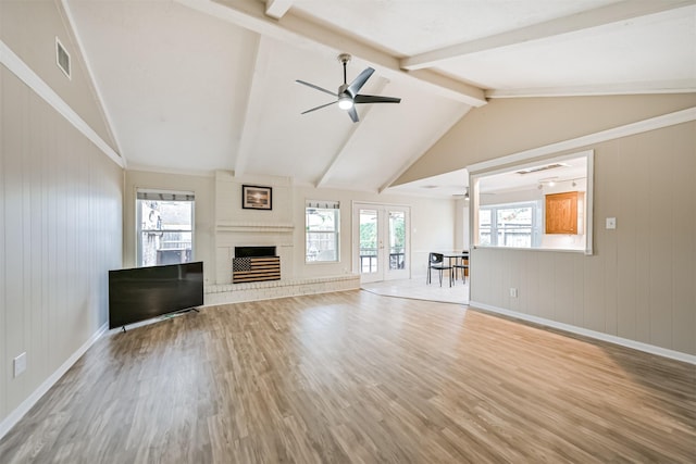 unfurnished living room with plenty of natural light, wood finished floors, visible vents, and french doors