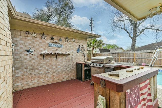 wooden deck with area for grilling and fence