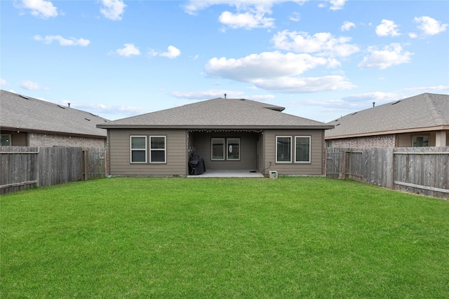 back of property featuring a lawn, a patio, a fenced backyard, and roof with shingles