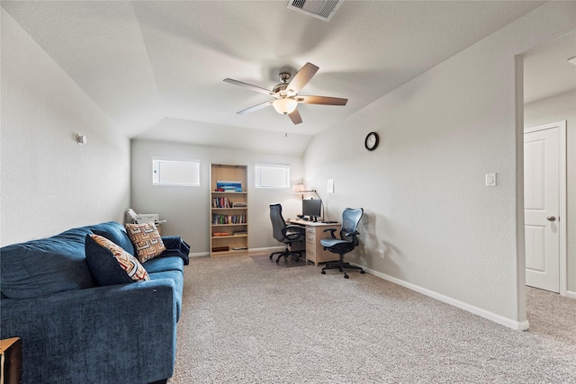 carpeted office space featuring vaulted ceiling, baseboards, visible vents, and ceiling fan