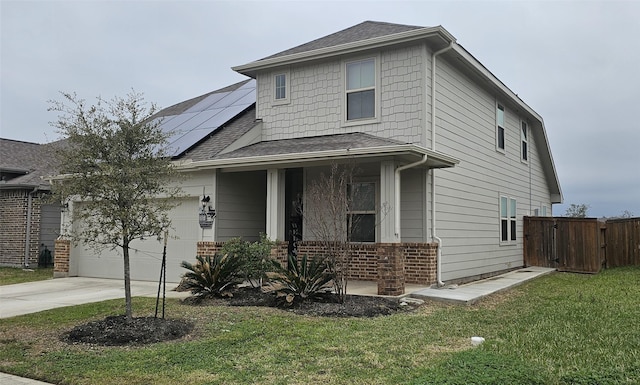 traditional home featuring a front lawn, roof mounted solar panels, a porch, concrete driveway, and an attached garage