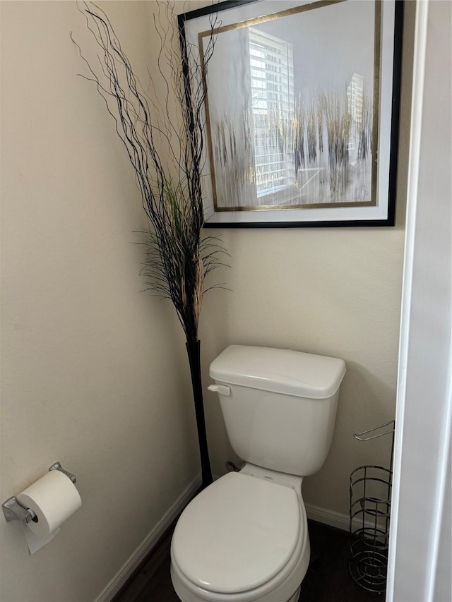 bathroom with toilet and baseboards