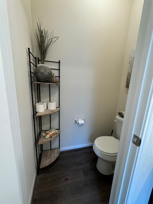 bathroom featuring baseboards, toilet, and wood finished floors