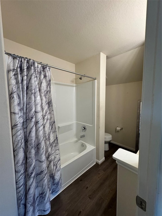 full bathroom with toilet, a textured ceiling, wood finished floors, shower / tub combo, and lofted ceiling