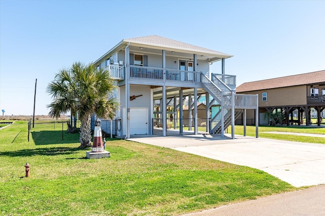 view of front of home featuring roof with shingles, concrete driveway, a front yard, a carport, and stairs