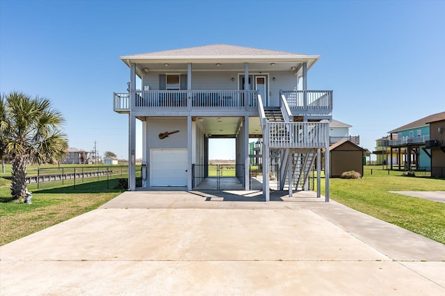 view of front facade with a front lawn, stairway, roof with shingles, concrete driveway, and a carport