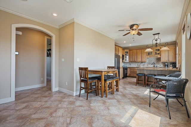 dining space with ornamental molding, a ceiling fan, recessed lighting, arched walkways, and baseboards