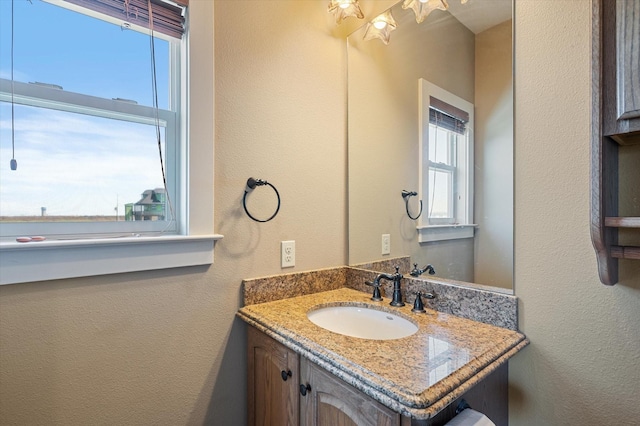 bathroom with vanity and a textured wall