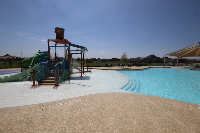 community pool featuring playground community and fence