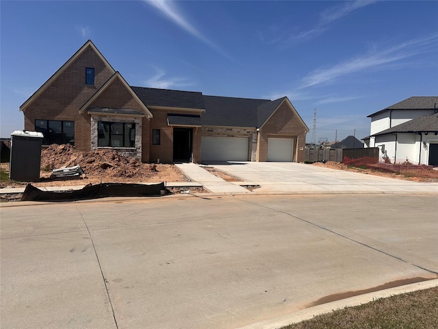 view of front of property featuring an attached garage, brick siding, and driveway