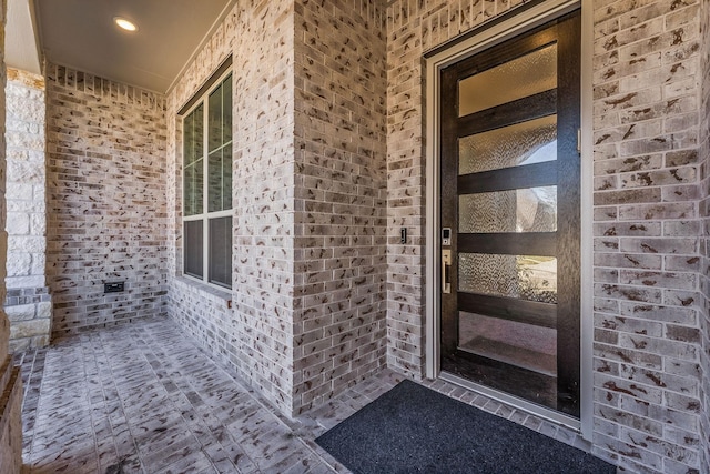 doorway to property featuring brick siding