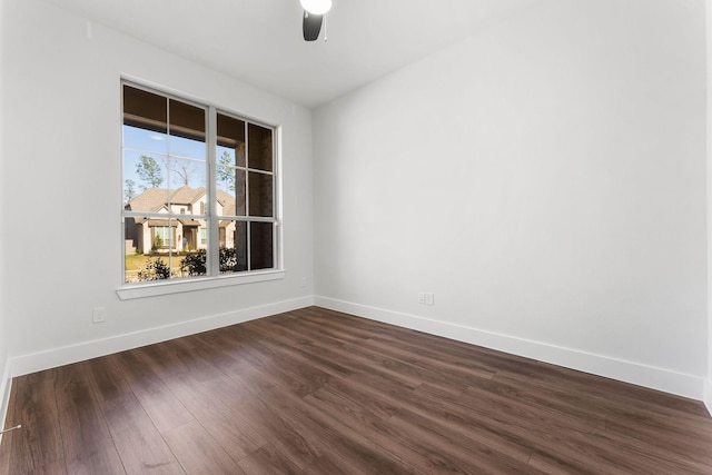 spare room featuring dark wood-style floors, baseboards, and ceiling fan