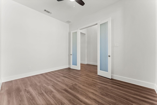 spare room with visible vents, baseboards, ceiling fan, and dark wood-style flooring