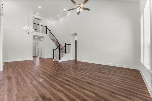 unfurnished living room with visible vents, baseboards, stairs, ceiling fan with notable chandelier, and dark wood-style floors