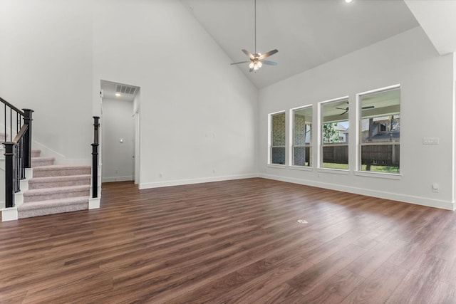 unfurnished living room featuring a ceiling fan, visible vents, high vaulted ceiling, dark wood-style flooring, and stairs