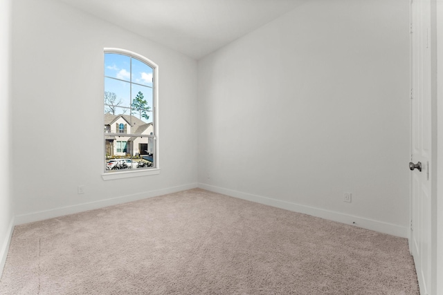 unfurnished room with carpet and baseboards