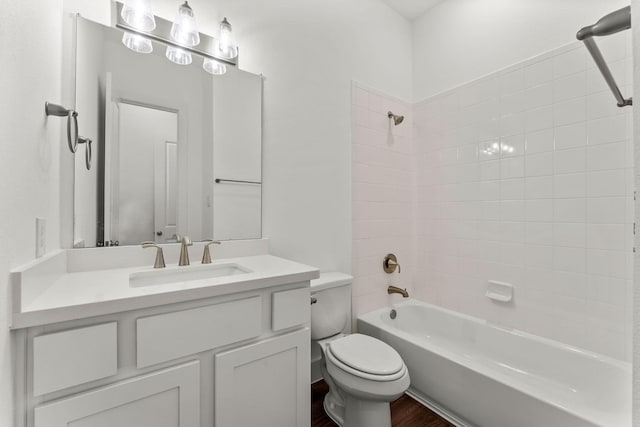 full bath with tub / shower combination, toilet, vanity, and wood finished floors