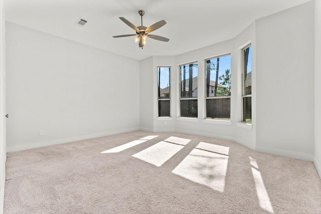 empty room with a ceiling fan, carpet, visible vents, and baseboards