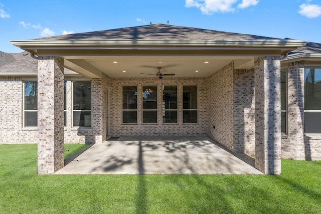 back of house featuring a patio, a lawn, roof with shingles, and ceiling fan