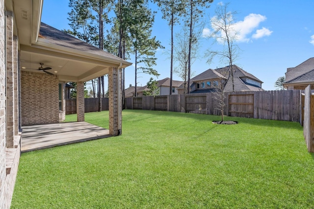 view of yard with a fenced backyard, a ceiling fan, and a patio area