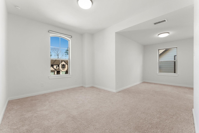 carpeted empty room with visible vents and baseboards