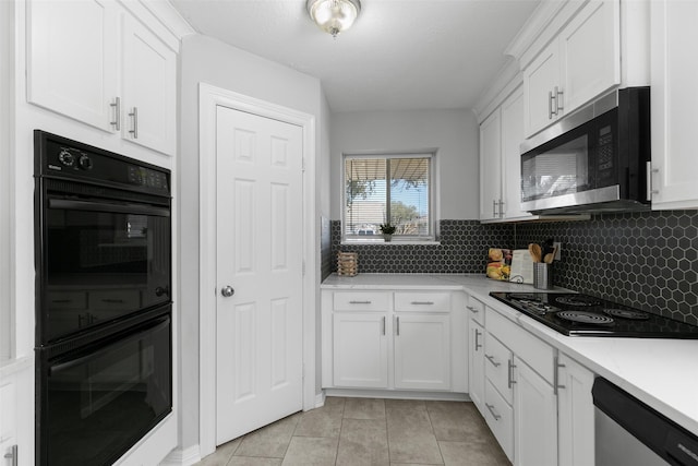 kitchen with white cabinetry, black appliances, light tile patterned floors, and light countertops