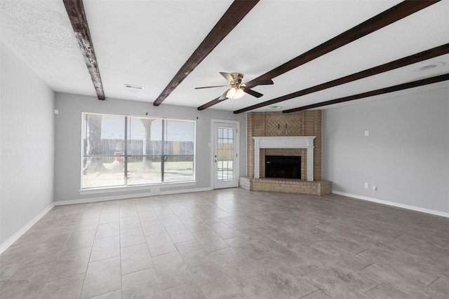 unfurnished living room with visible vents, baseboards, beamed ceiling, ceiling fan, and a brick fireplace